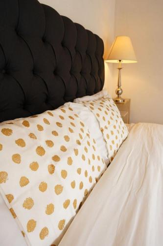 a close up of a bed with a black headboard at Cabaña El Encino III en Real del Monte in Mineral del Monte