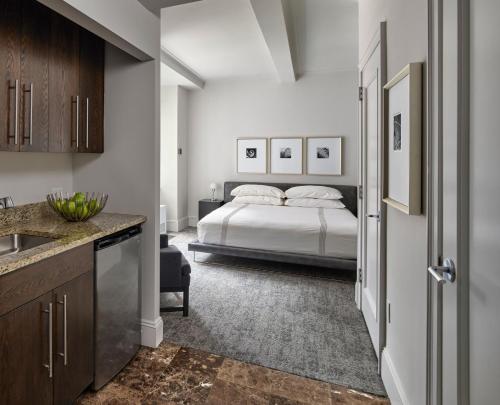 a bedroom with a bed and a kitchen with a sink at AKA Central Park in New York