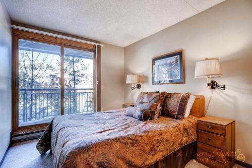 a bedroom with a bed and a large window at RECENTLY UPDATED Ski In & Out Condo with Heated Garage Parking and VIEWS! TE303 in Breckenridge