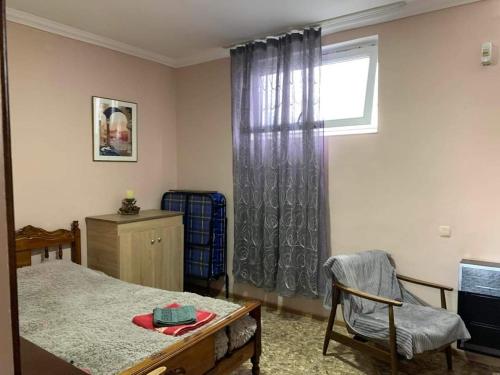 a room with a bed and a window and a chair at giomana in Borjomi