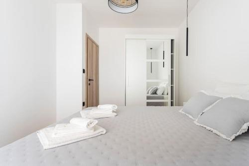 Un dormitorio blanco con una cama blanca con toallas. en Amazing sea view place with swimming pool, en Sveta Nedelja