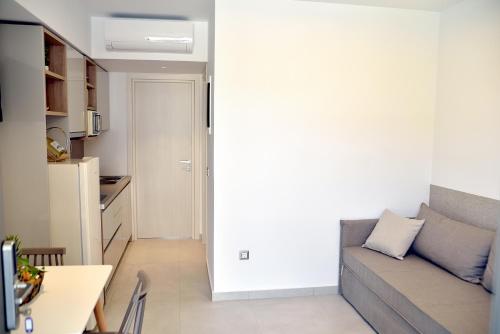 a living room with a couch and a kitchen at KOUROS STONE SUITES in Haraki