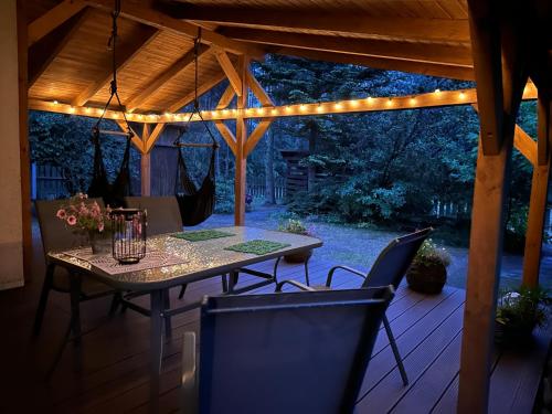 un patio con mesa y sillas bajo una pérgola en Bory Tucholskie Domek Starzyska, en Osówek