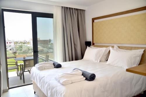 a hotel room with a bed with towels on it at KOUROS STONE SUITES in Haraki