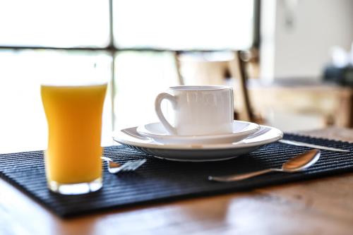 un vaso de zumo de naranja y una taza de café sobre una mesa en Pousada Capitólio, en Capitólio