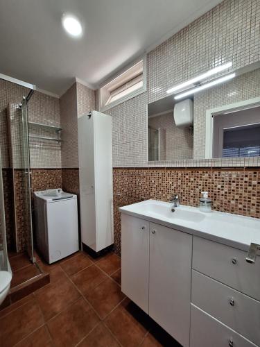 a bathroom with a sink and a toilet and a mirror at Horizon Views - Excellent location with ocean view in Puerto Rico de Gran Canaria