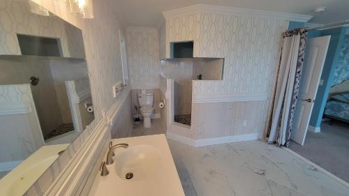 a bathroom with a tub and a toilet in it at 8018 Beach Rd, Semi-Oceanfront, Pool/Hot Tub in Nags Head