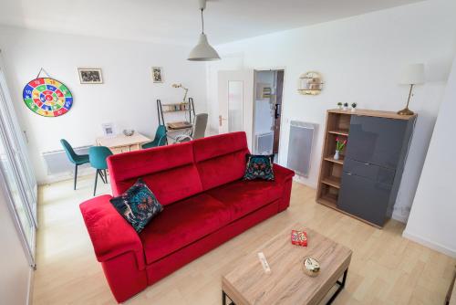 a living room with a red couch and a table at Les jardins de Rangueil, Parking, Métro, Piscine in Toulouse