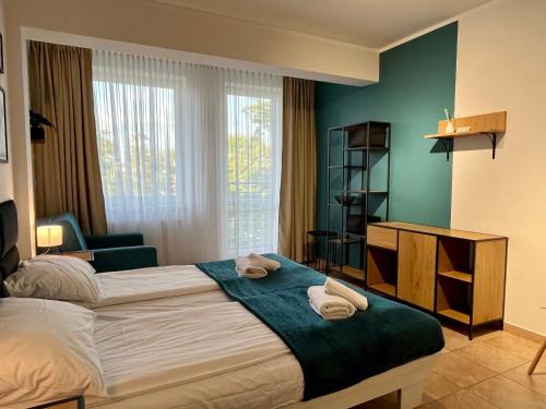 une chambre avec un lit avec des serviettes dessus dans l'établissement Apartament 205 Planeta Mielno 100 m od plaży, à Mielno