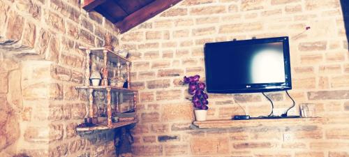 a tv hanging on a brick wall at Leggiero in Benkovac