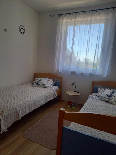 a bedroom with two beds and a window at Leggiero in Benkovac