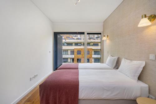a bedroom with a large bed and a large window at WHome Urban Retreat w/Parking, Elevator & AC by Benfica Stadium in Lisbon