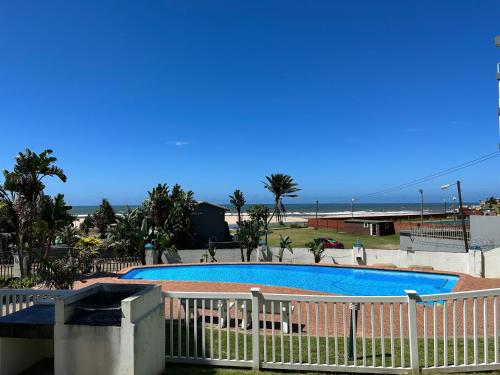 a swimming pool with the ocean in the background at Colonial Sands 403 in Margate