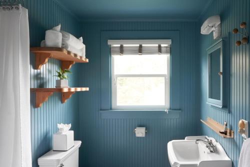 Baño azul con aseo y lavamanos en The Drifthaven at Gearhart en Gearhart