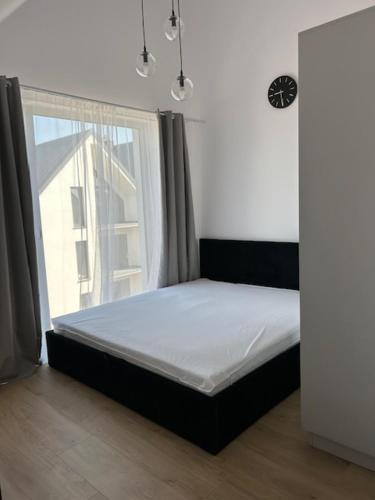 a bed in a room with a large window at Apartament w Ustroniu Morskim Słoneczne Apartamenty in Ustronie Morskie