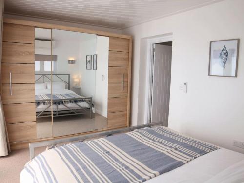 a bedroom with a bed and a large mirror at Ocean View apartment, beautiful sea views in Kent