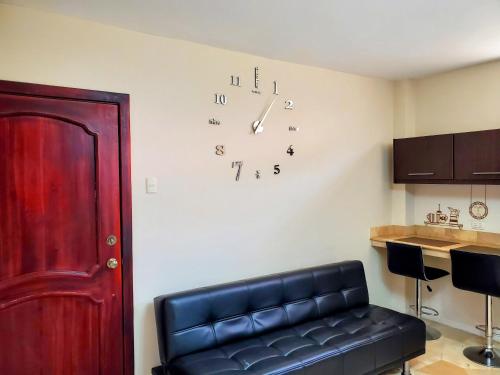 a room with a couch and a clock on the wall at NCG Suite in Guayaquil