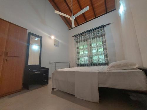 a bedroom with a large bed and a window at Green Stay in Habaraduwa Central