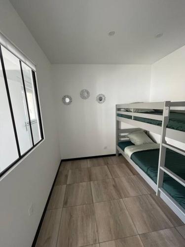 a room with two bunk beds and a window at Maison proche Le Pal in Neuilly-le-Réal