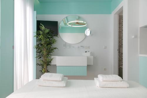 a bedroom with a white bed and a mirror at Flora Apartments & Studios in Agia Anna Naxos