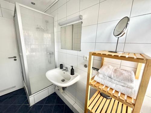 a white bathroom with a sink and a mirror at BocholtApartments in Bocholt