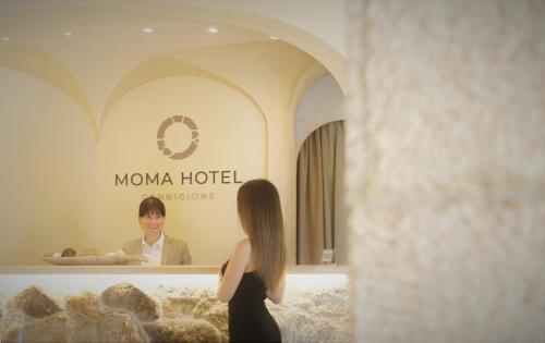 een vrouw in een zwarte jurk die naar een man kijkt bij Moma Hotel Cannigione in Cannigione