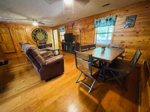 uma sala de estar com uma mesa e um sofá em Smoky Mountain Enchanting Haven 3BR2BA Cabin em Sevierville