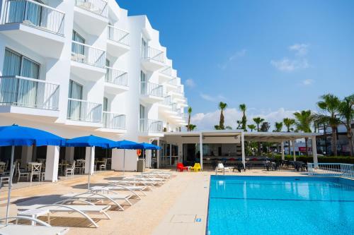 a hotel with a swimming pool and chairs and umbrellas at Napa Jay Hotel in Ayia Napa