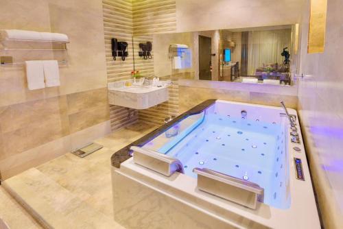 烏姆拉吉的住宿－Wissam Al-Hawra Hotel，一间带按摩浴缸和水槽的浴室