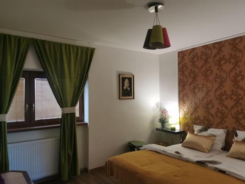 um quarto com uma cama com cortinas verdes e uma janela em AG Apartment Gabčíkovo em Dunajská Streda