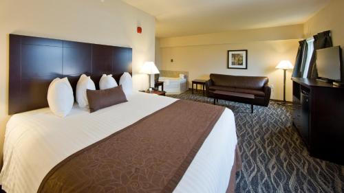a hotel room with a large bed and a chair at Cobblestone Inn & Suites - Boone in Boone