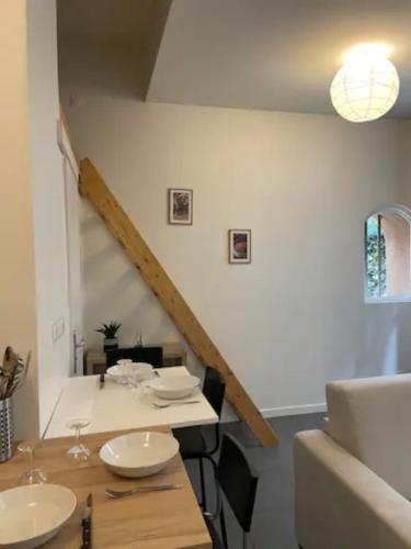une salle à manger avec une table et un escalier dans l'établissement Le Petit Balzac-cosy 2pers-Villeurbanne, à Villeurbanne