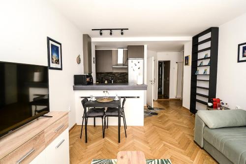 a kitchen and a living room with a table at Apartment Petra 073 in Belgrade