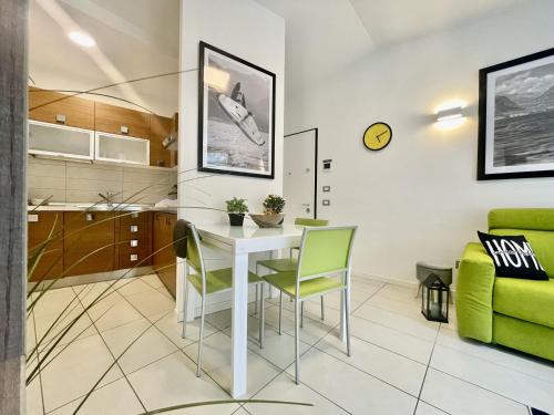 a living room with a white table and green chairs at Outdooredo Garda Torbole in Nago-Torbole