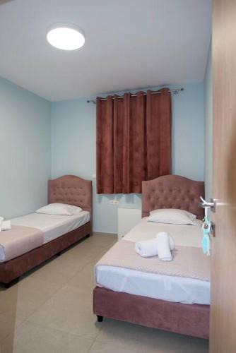 two beds in a room with red curtains at Iliovasilema in Mírton