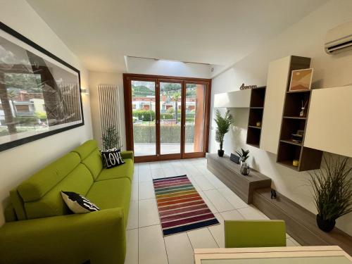- un salon avec un canapé vert et une fenêtre dans l'établissement Outdooredo Garda Torbole, à Nago-Torbole