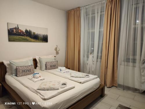 Schlafzimmer mit einem Bett mit weißer Bettwäsche und einem Fenster in der Unterkunft Buon Studio-romantic little cottage near Small Square in Sibiu