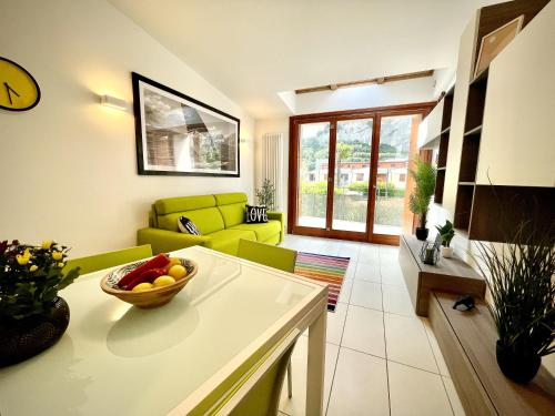 a living room with a couch and a bowl of fruit on a table at Outdooredo Garda Torbole in Nago-Torbole