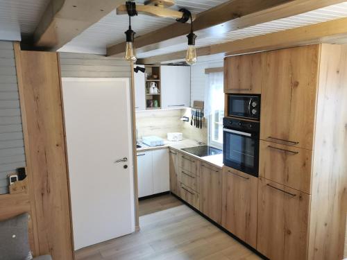 uma cozinha com armários de madeira e um forno com placa de fogão em Cosy Retreat Čatež em Catez ob Savi
