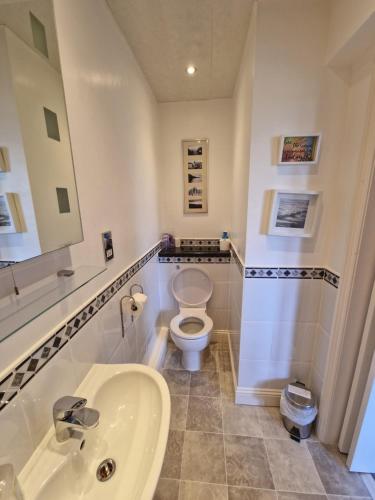 uma casa de banho com um WC branco e um lavatório. em Hay Farm House em Ford