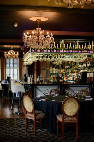 a dining room with a table with chairs and a chandelier at Ye Olde Bell Hotel & Spa in Retford