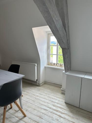 Habitación blanca con mesa y ventana en Appartements im Katzensteinhaus en Rotenburg an der Fulda