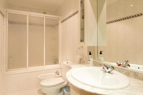 a white bathroom with a sink and a toilet at Pension Logroño in Logroño