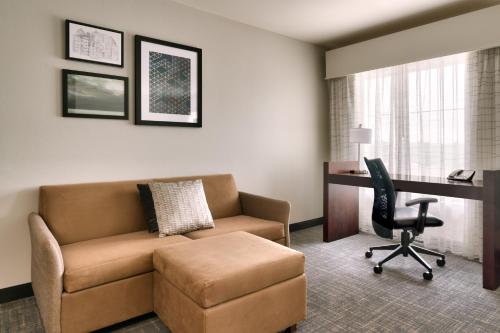 a living room with a couch and a desk and a chair at Residence Inn by Marriott Houston I-10 West/Park Row in Houston