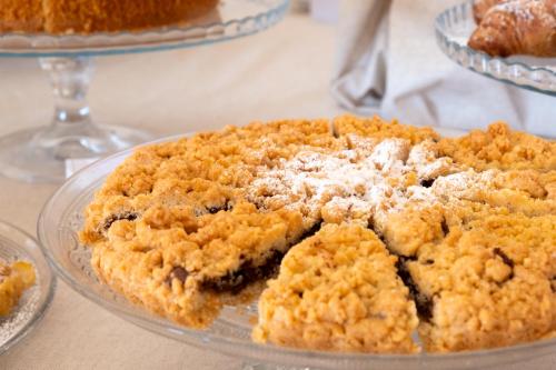 a blueberry crumble pie on a glass plate on a table at Moma Hotel Cannigione in Cannigione