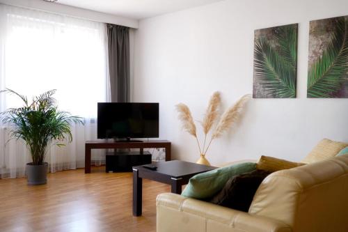 a living room with a couch and a tv at Makas Apartamenty in Świnoujście