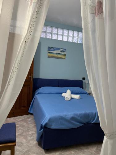 een slaapkamer met een bed met blauwe lakens en gordijnen bij Casa Francesco in Ischia