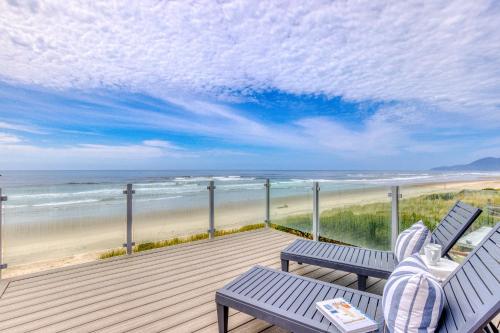 a deck with two benches and a view of the beach at Salty Shore in Rockaway Beach
