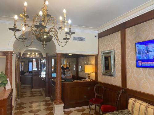 a hotel lobby with a chandelier and a bar at Hotel Falier in Venice