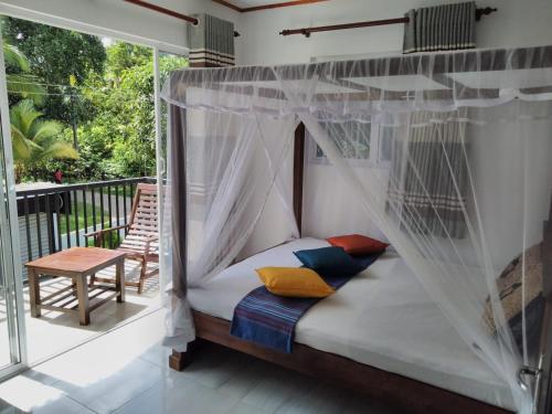 a bedroom with a canopy bed on a balcony at Dream Forest Rest in Ahangama